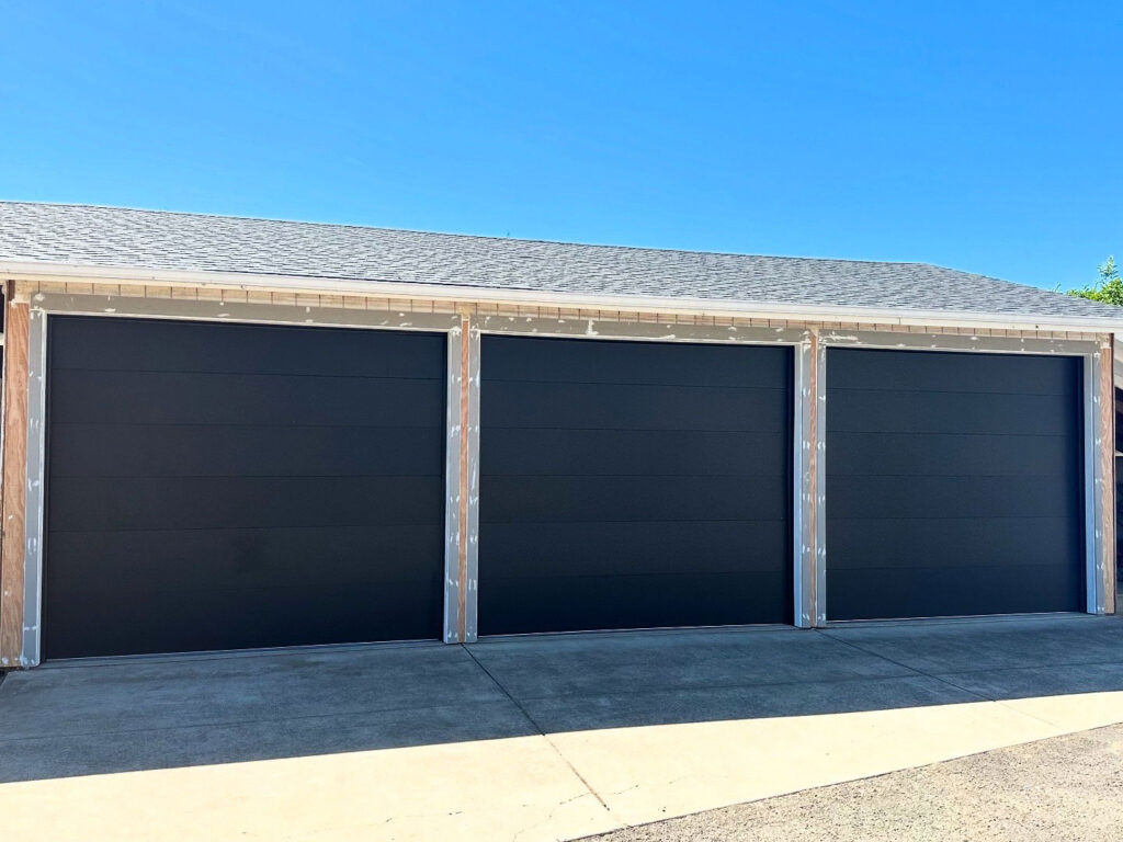 Three dark bronze garage doors installed on a building in Eugene, Oregon
