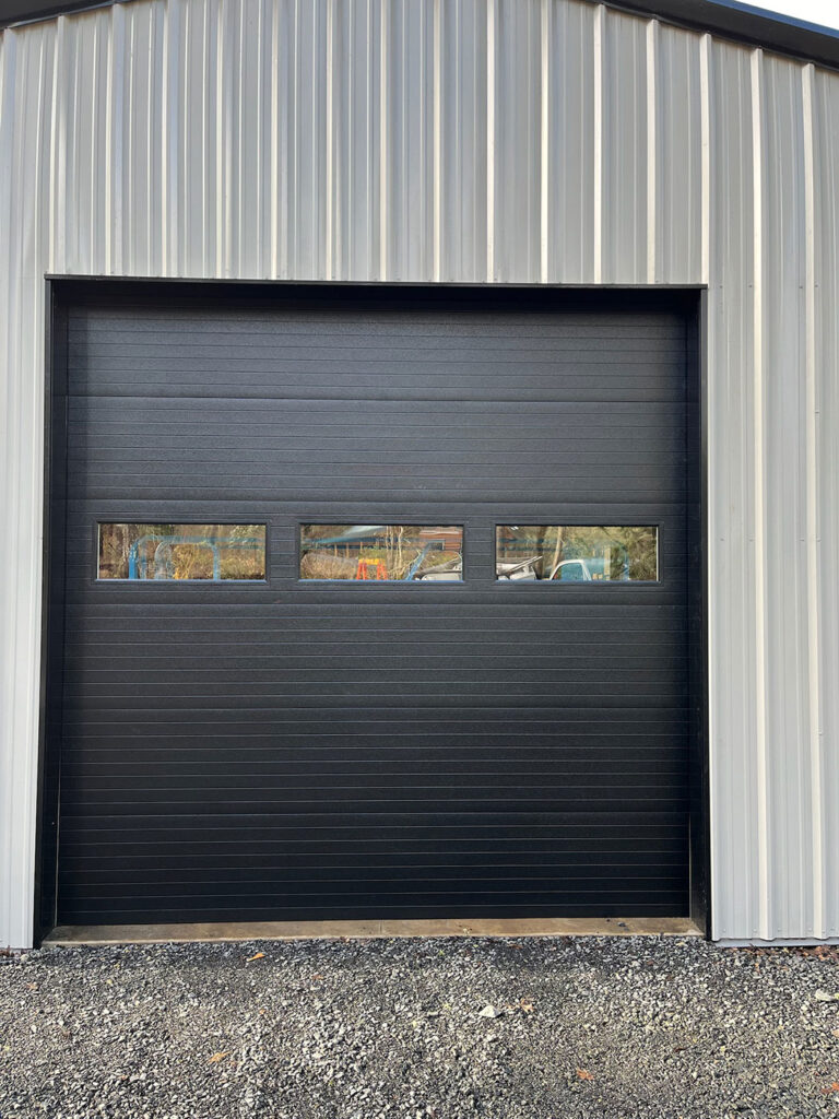 Dark commercial sectional garage door with a window row