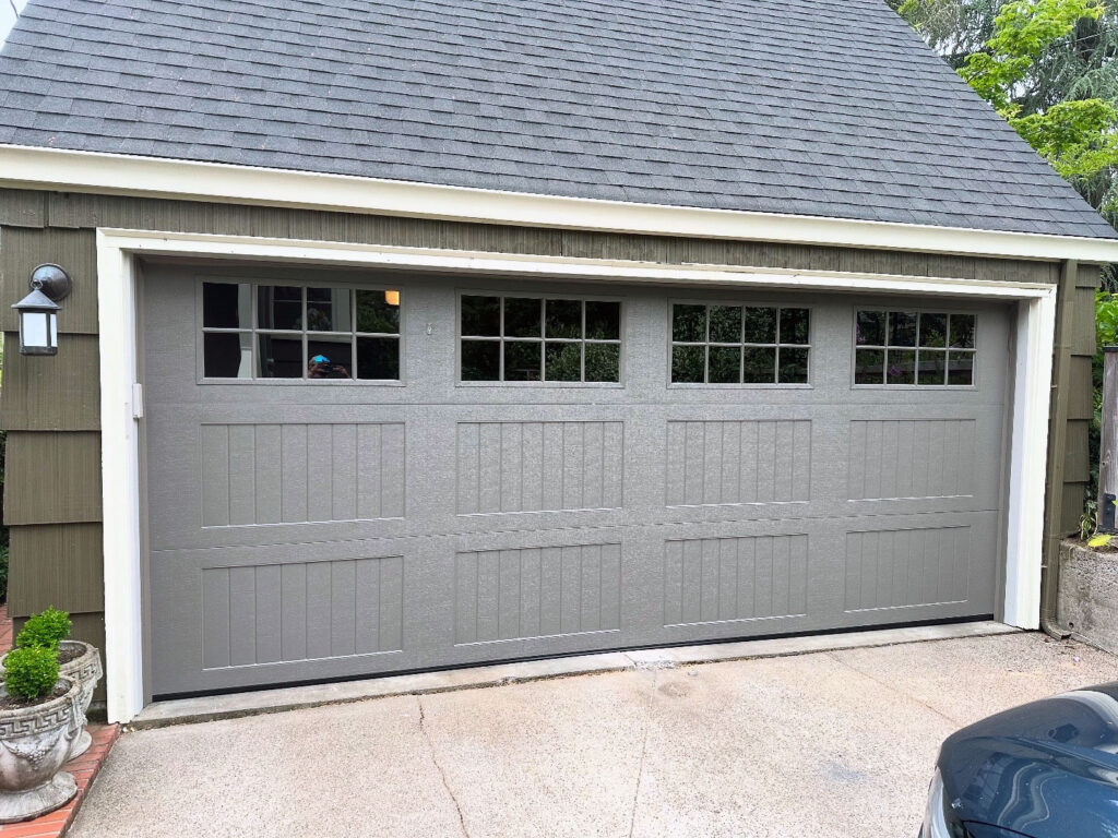 Gray sectional garage door with a window row on a Eugene, Oregon home