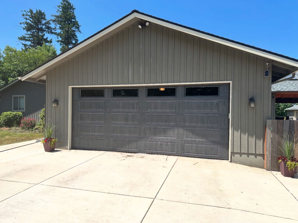 Tan ranch home with a gray double garage door in Eugene, Oregon