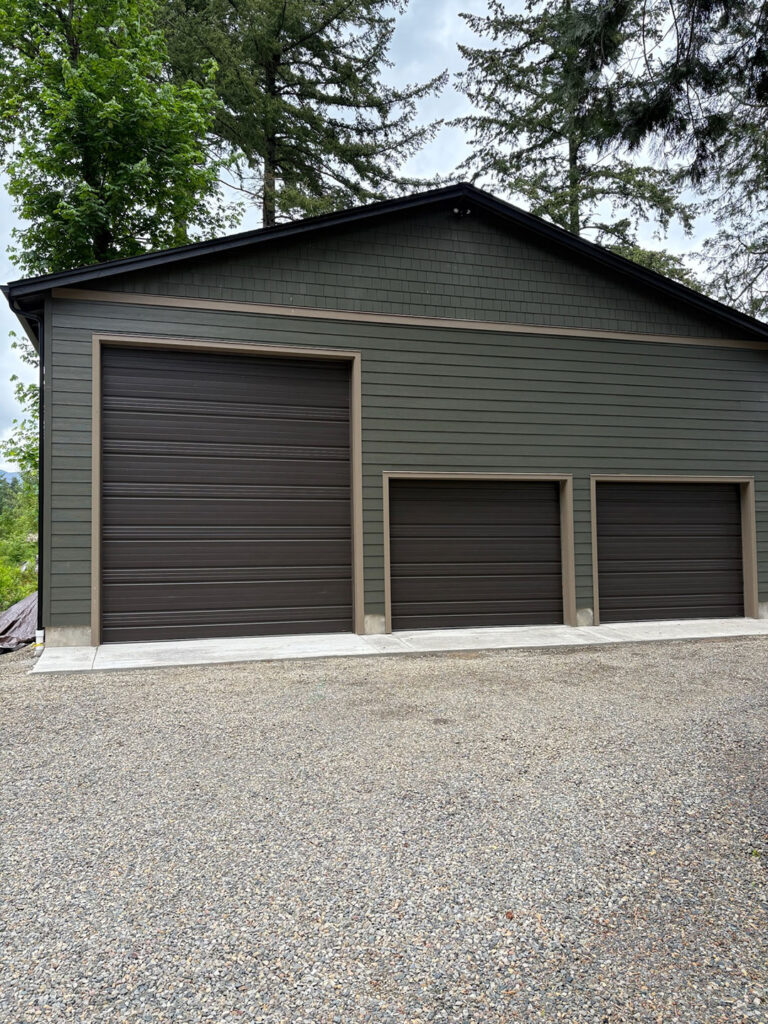 Commercial rolling steel doors on a green metal building in Lane County, Oregon