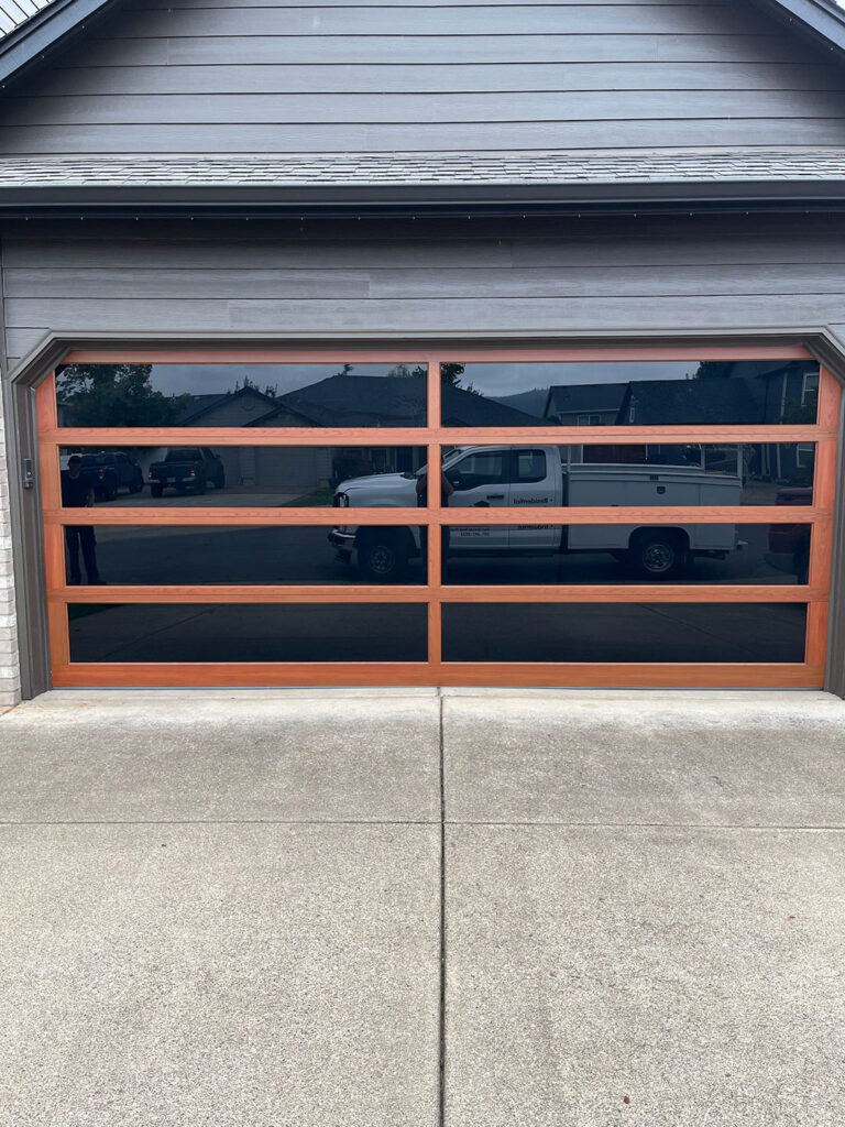 Full-view glass and wood modern garage door installed in Eugene, Oregon
