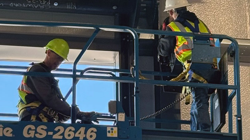 Crawford Windor technicians installing a commercial garage door from a lift