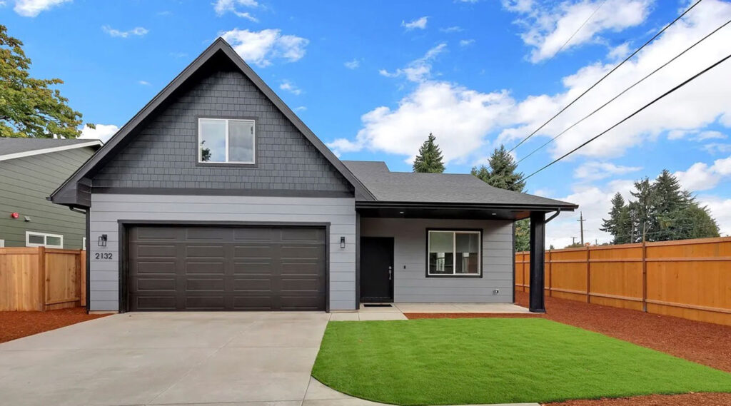 Two-story home with a dark double garage door and landscaped yard in Eugene, Oregon
