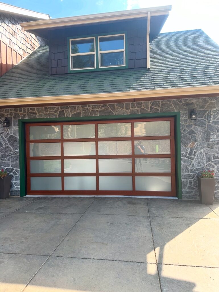 Full-view glass and wood-framed custom garage door on an Oregon home