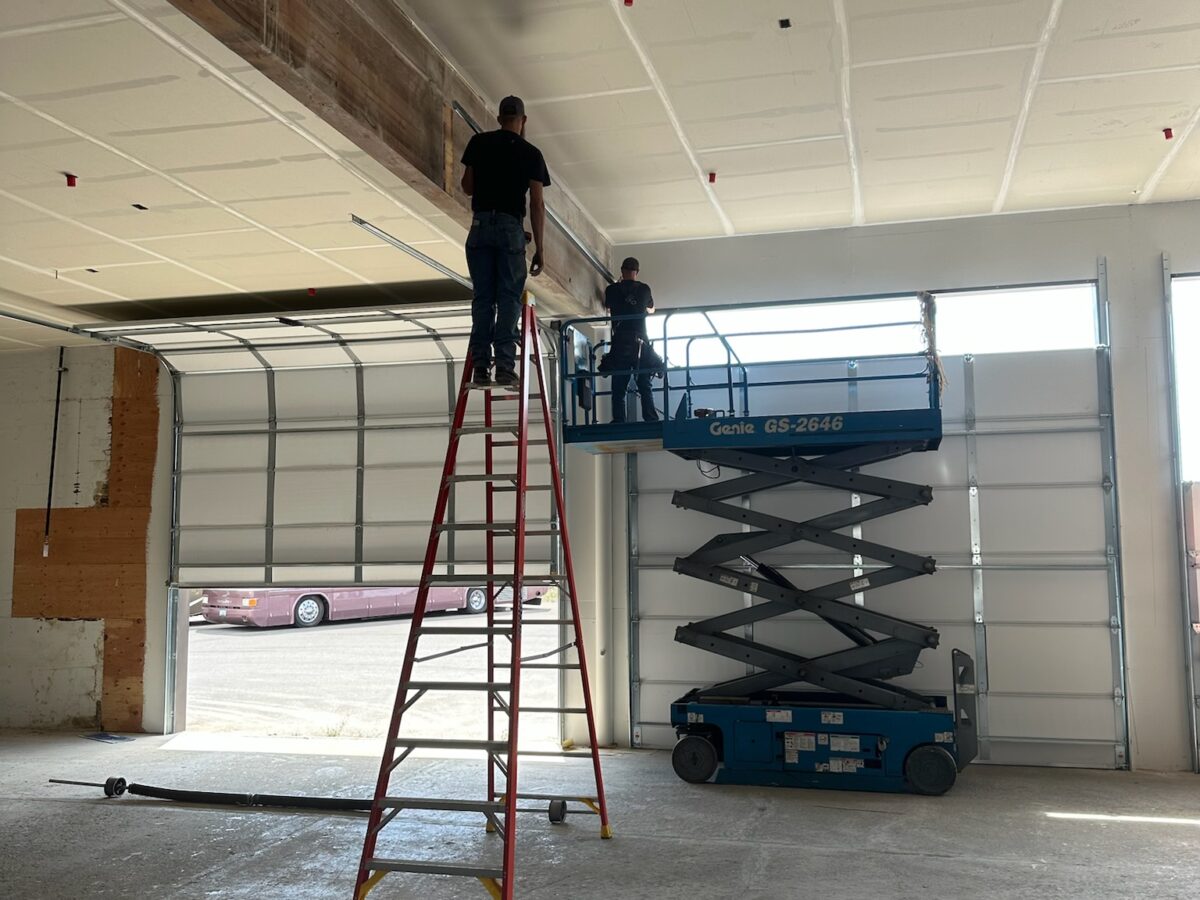 Crawford Windor crew fitting a commercial door in Eugene, Oregon — the team behind these garage door tips