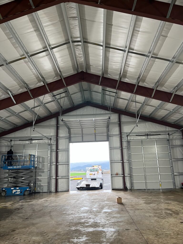 Inside a steel building near Eugene, Oregon with an industrial garage door open to the yard